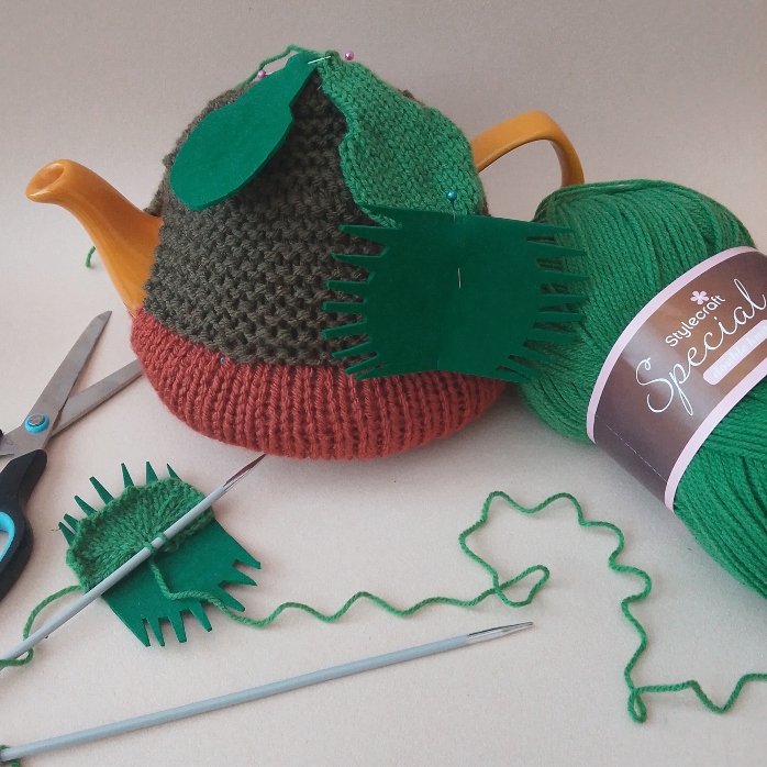funky foam template pinned in place on tea cosy to check knitting scale and proportions