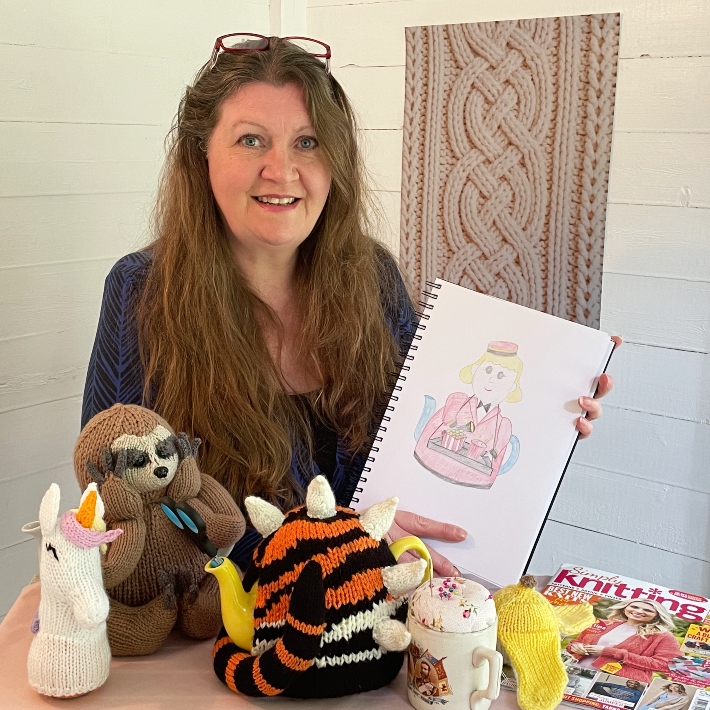 Suzy Cowper and her tea cosies and chocolate orange covers int he summerhouse for the TeaCosyFolk's Knitting Vlog for May 2026